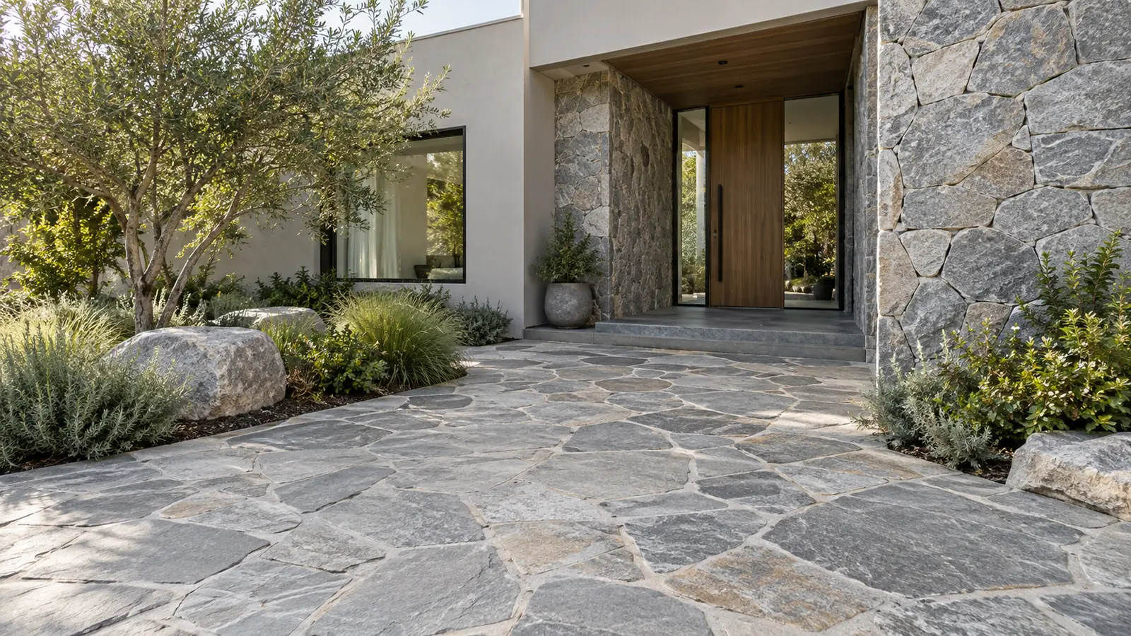 Patio de ingreso con piso de lajas grises irregulares